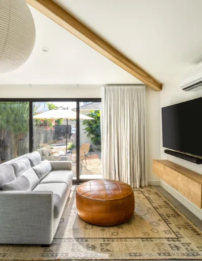 A modern living room with wooden beams and a flat screen tv.